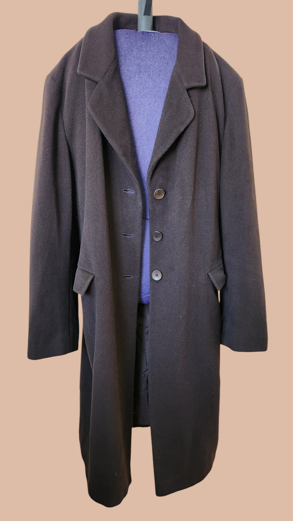 Dark gray coat on a mannequin against a beige background