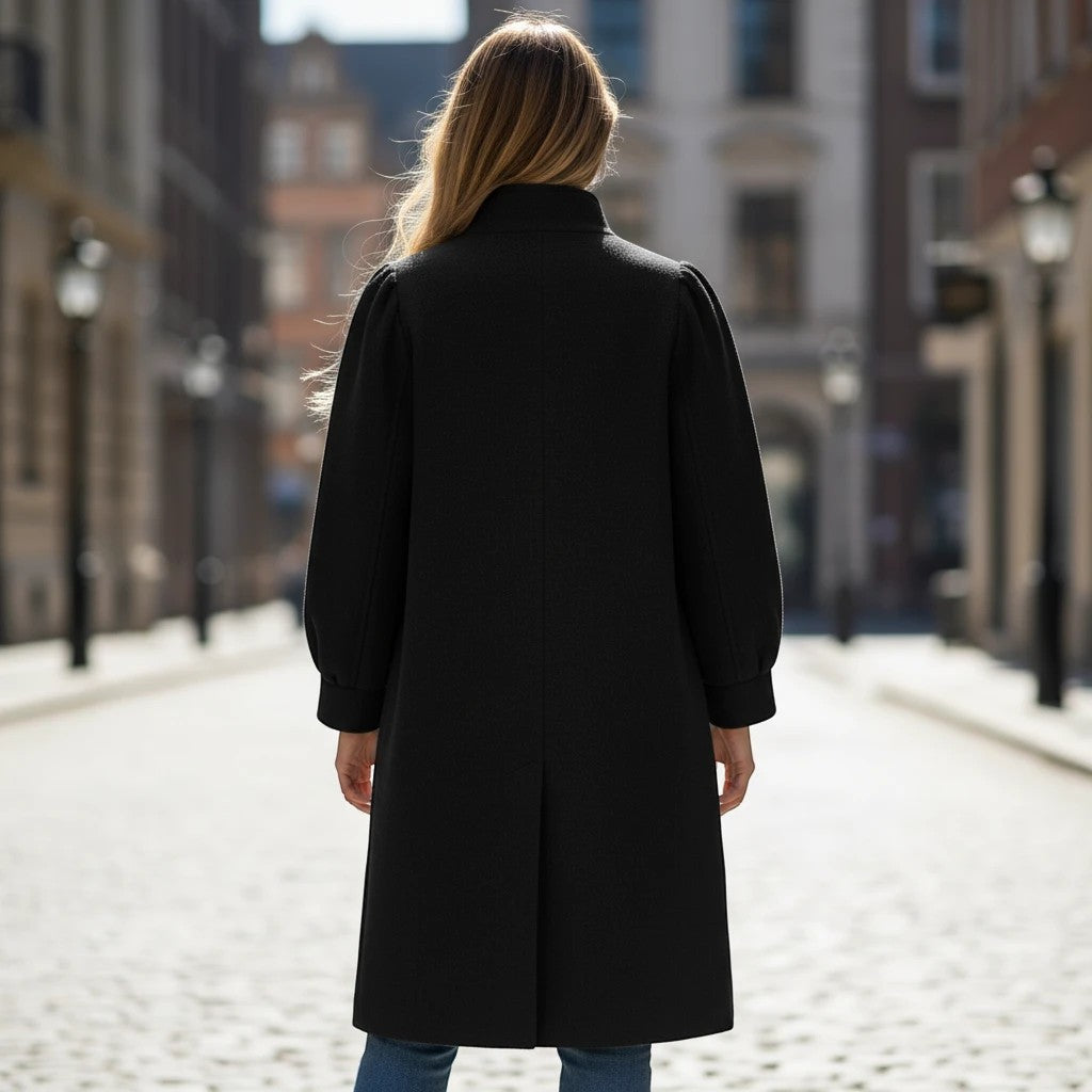 Z&A black longline coat with voluminous sleeves and high-neck collar worn by a woman on a cobblestone street